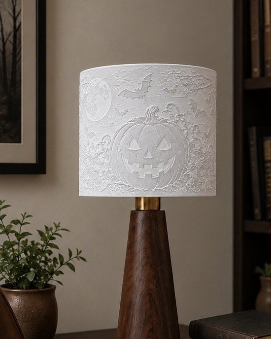 The Hallows Glow lamp switched off: a pale pumpkin relief on a wood base